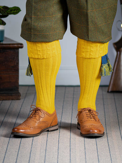 Long knitted shooting socks with a cable turnover in a bright canary yellow.