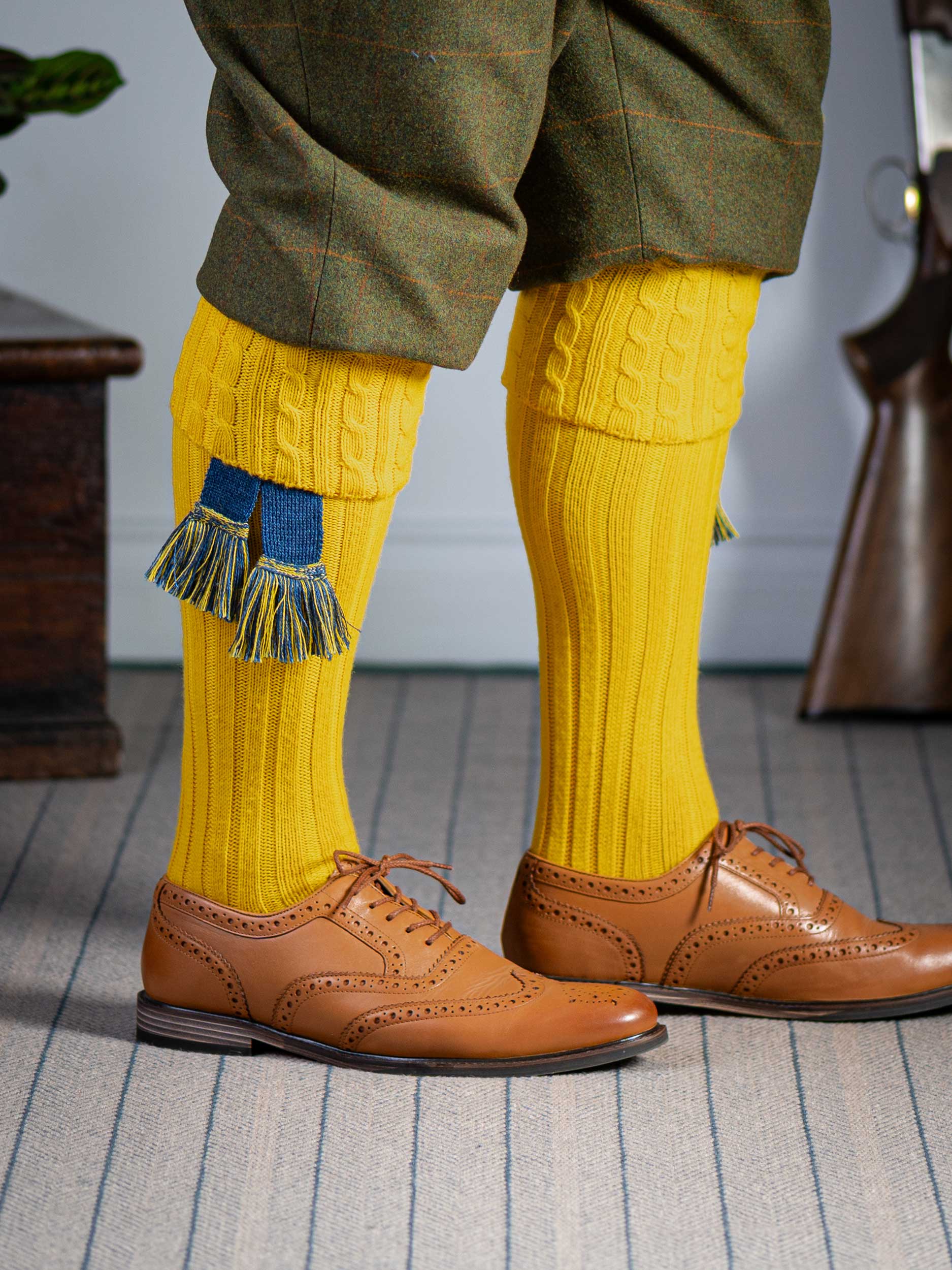 Long knitted shooting socks with a cable turnover in a bright canary yellow.