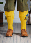 Long knitted shooting socks with a cable turnover in a bright canary yellow.