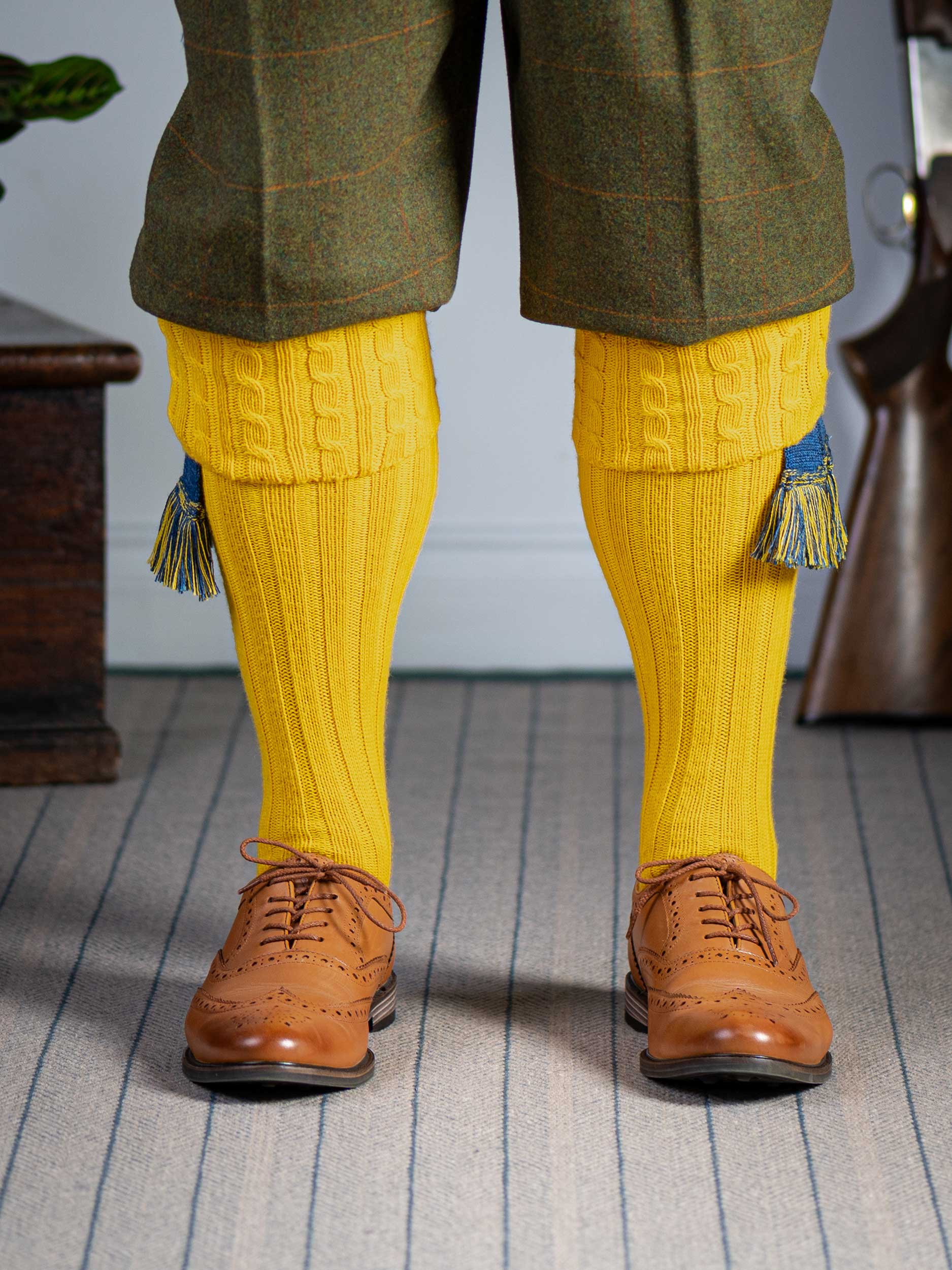 Long knitted shooting socks with a cable turnover in a bright canary yellow.
