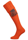 Long knitted shooting socks with a cable turnover in a bright orange nasturtium.