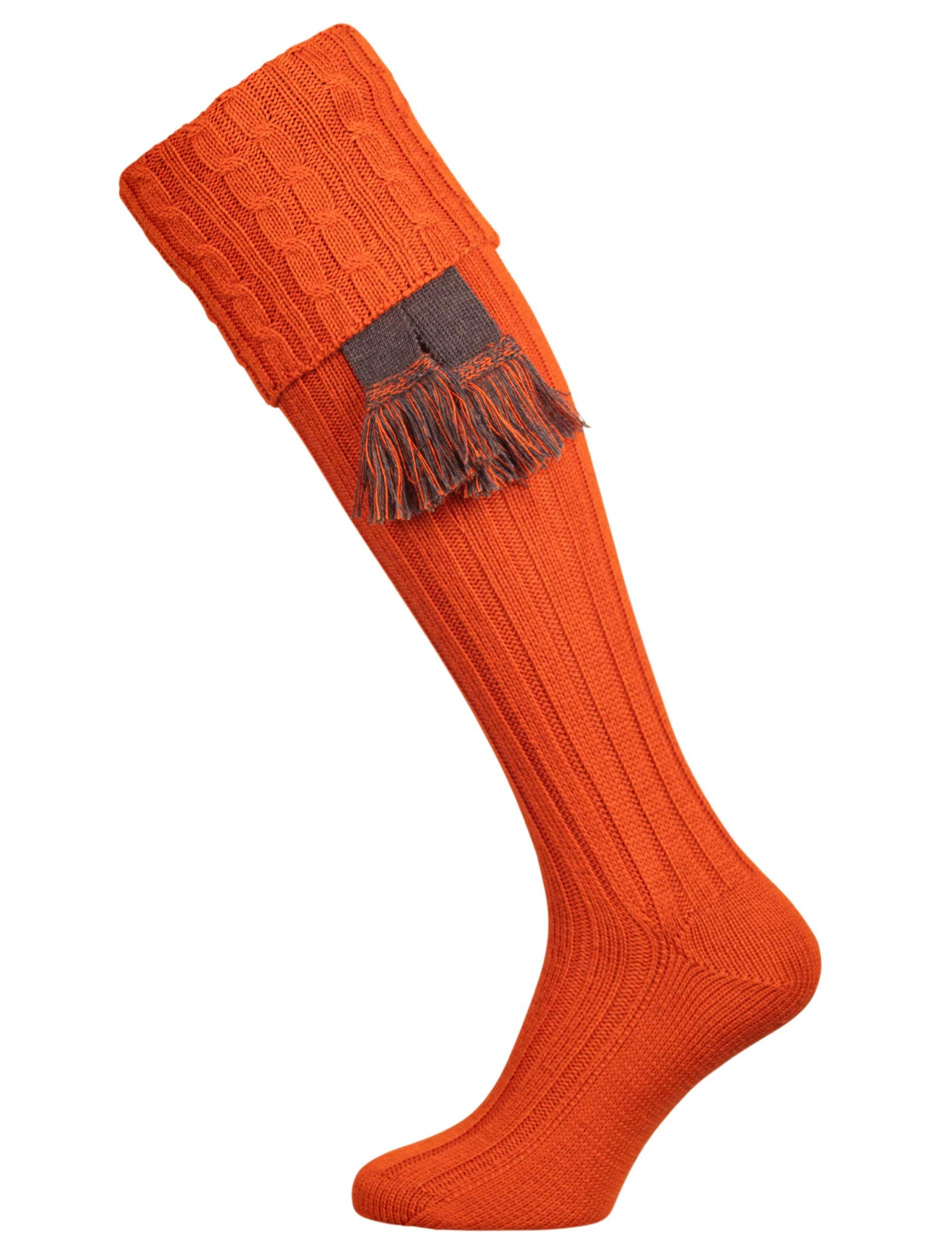 Long knitted shooting socks with a cable turnover in a bright orange nasturtium.