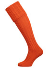 Long knitted shooting socks with a cable turnover in a bright orange nasturtium.
