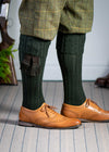 Long knitted shooting socks with a cable turnover in a very dark green.