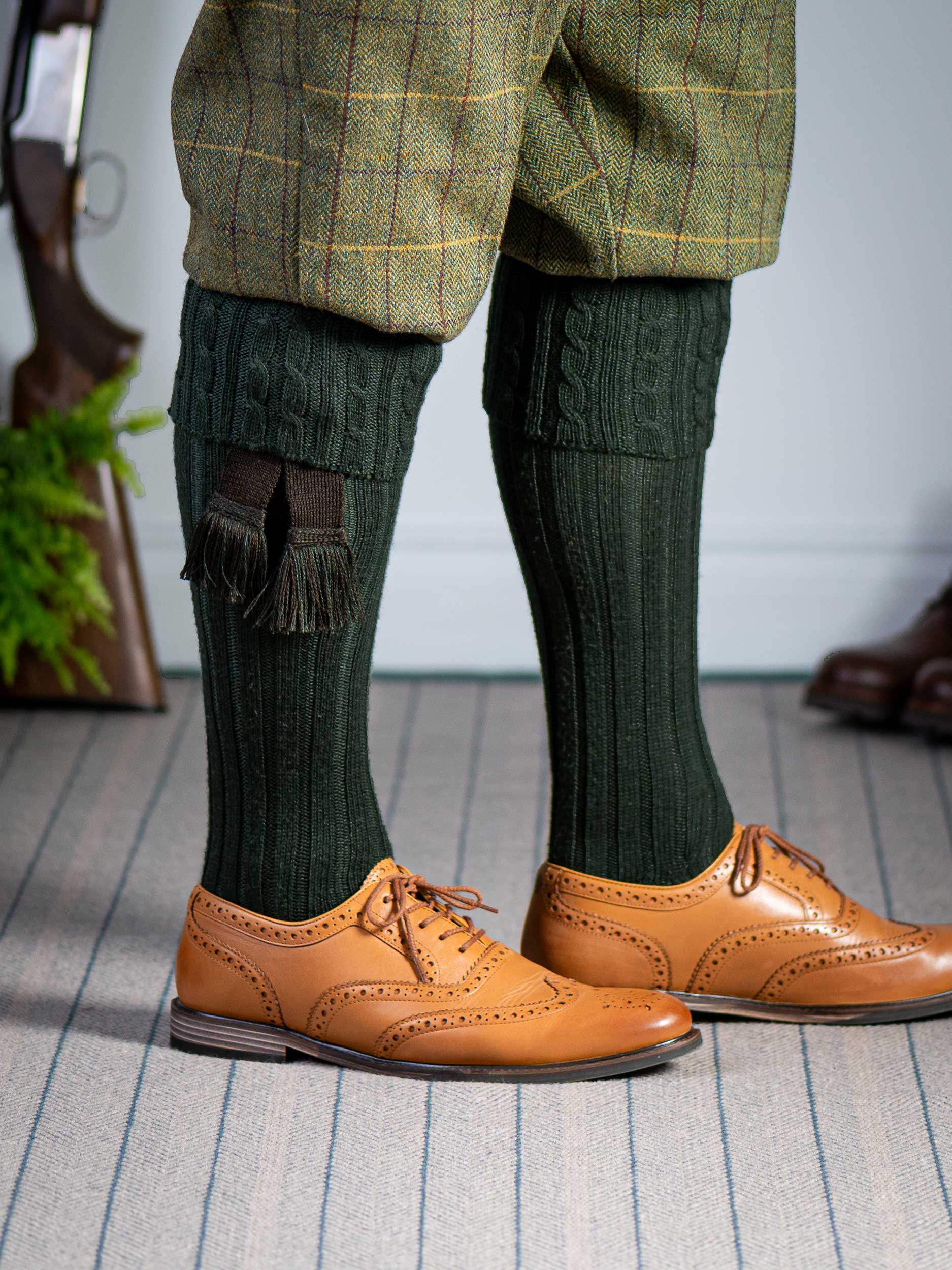 Long knitted shooting socks with a cable turnover in a very dark green.