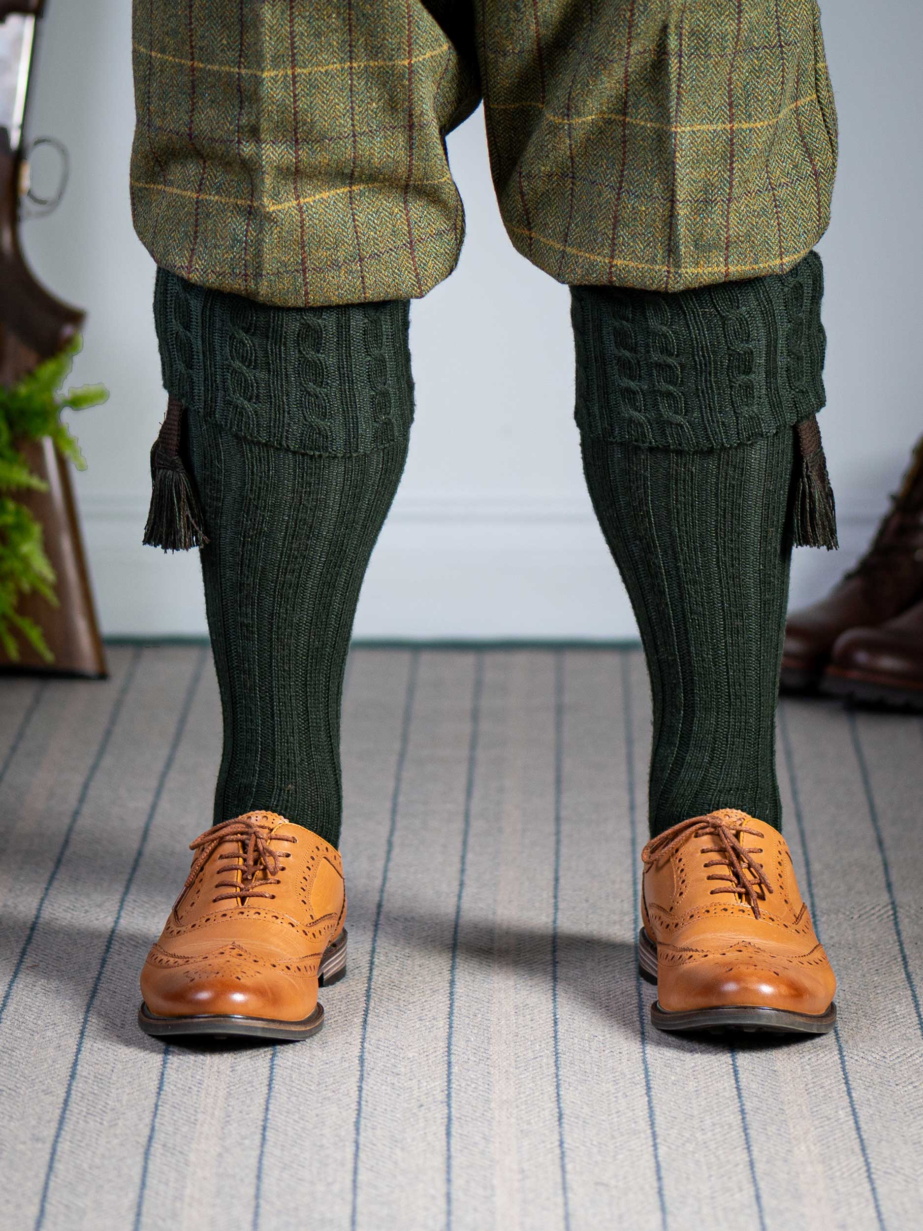 Long knitted shooting socks with a cable turnover in a very dark green.