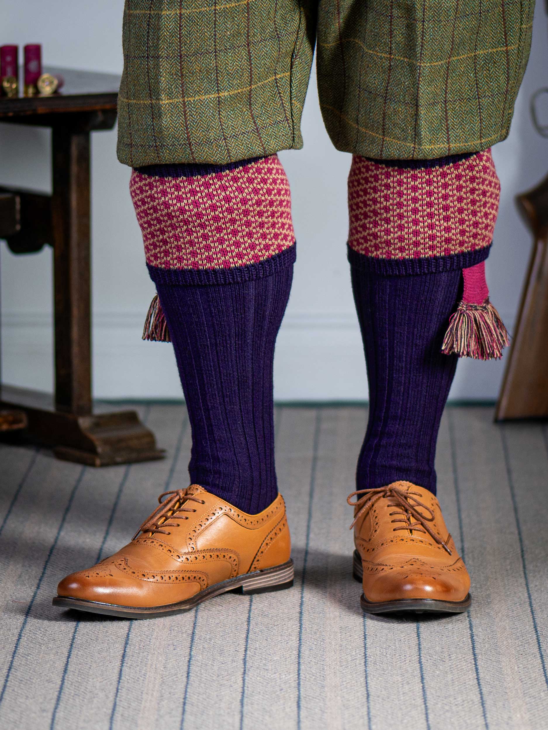 Long knitted shooting socks with a ribbed leg. Dark purple with a deep pink and camel pattern in the turnover top.
