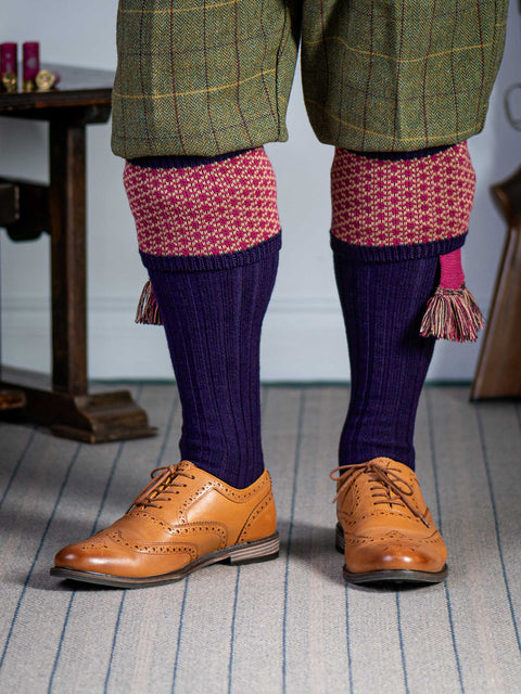 Long knitted shooting socks with a ribbed leg. Dark purple with a deep pink and camel pattern in the turnover top.