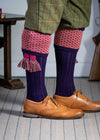 Long knitted shooting socks with a ribbed leg. Dark purple with a deep pink and camel pattern in the turnover top.
