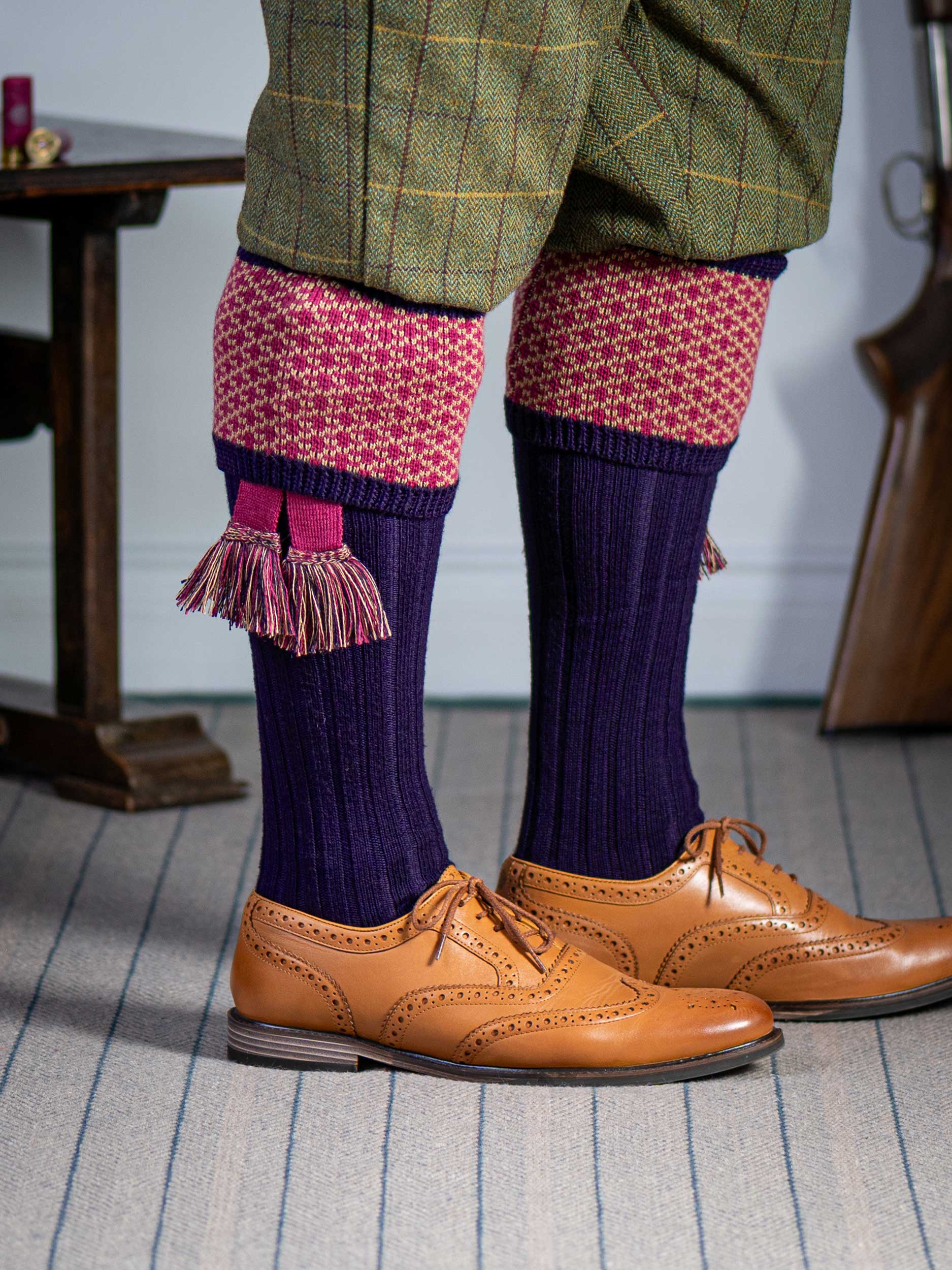 Long knitted shooting socks with a ribbed leg. Dark purple with a deep pink and camel pattern in the turnover top.
