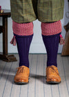 Long knitted shooting socks with a ribbed leg. Dark purple with a deep pink and camel pattern in the turnover top.