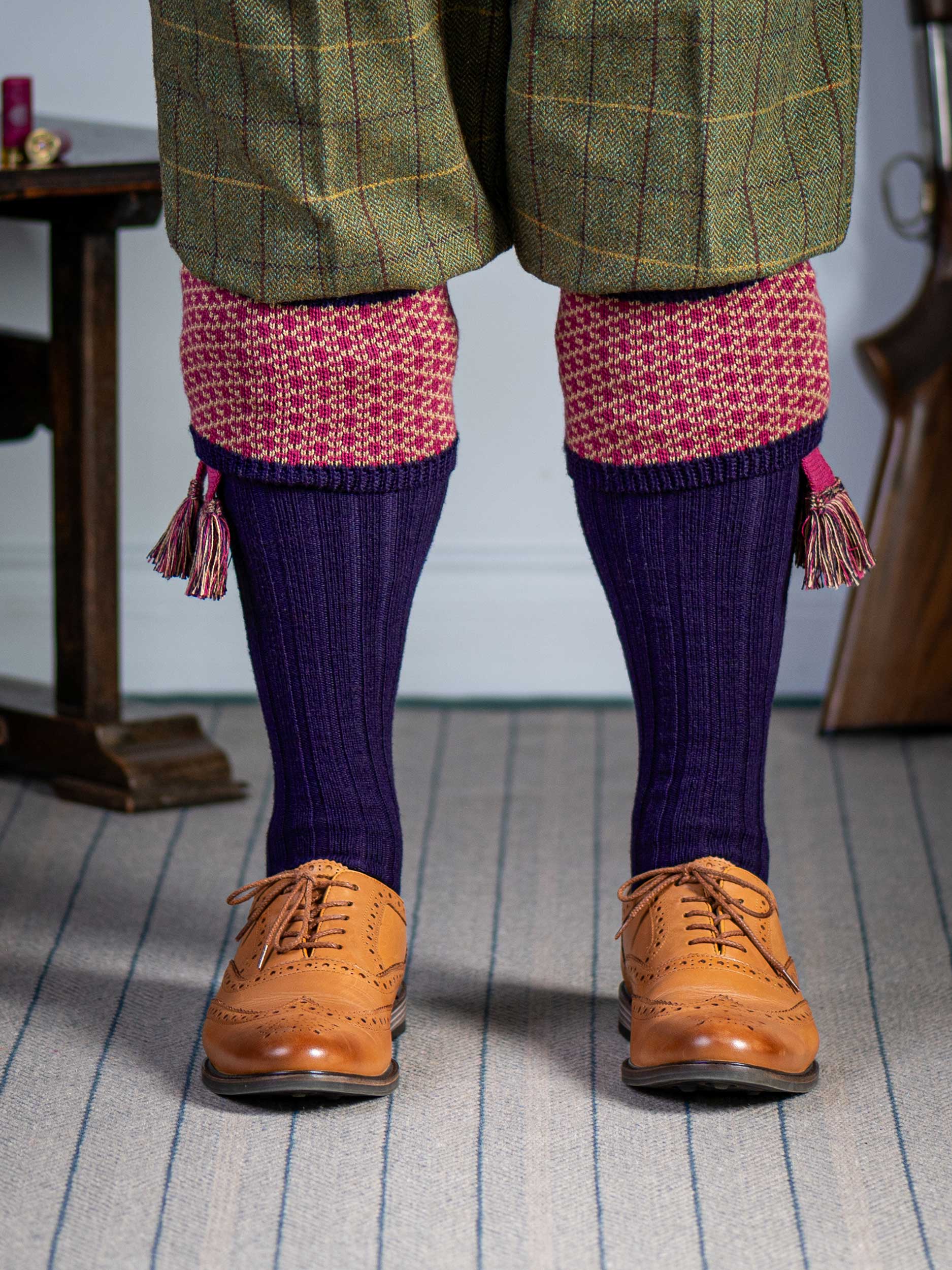 Long knitted shooting socks with a ribbed leg. Dark purple with a deep pink and camel pattern in the turnover top.