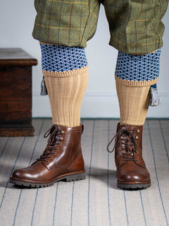 Long knitted shooting socks with a ribbed leg. Beige with a navy and sky blue pattern in the turnover top.