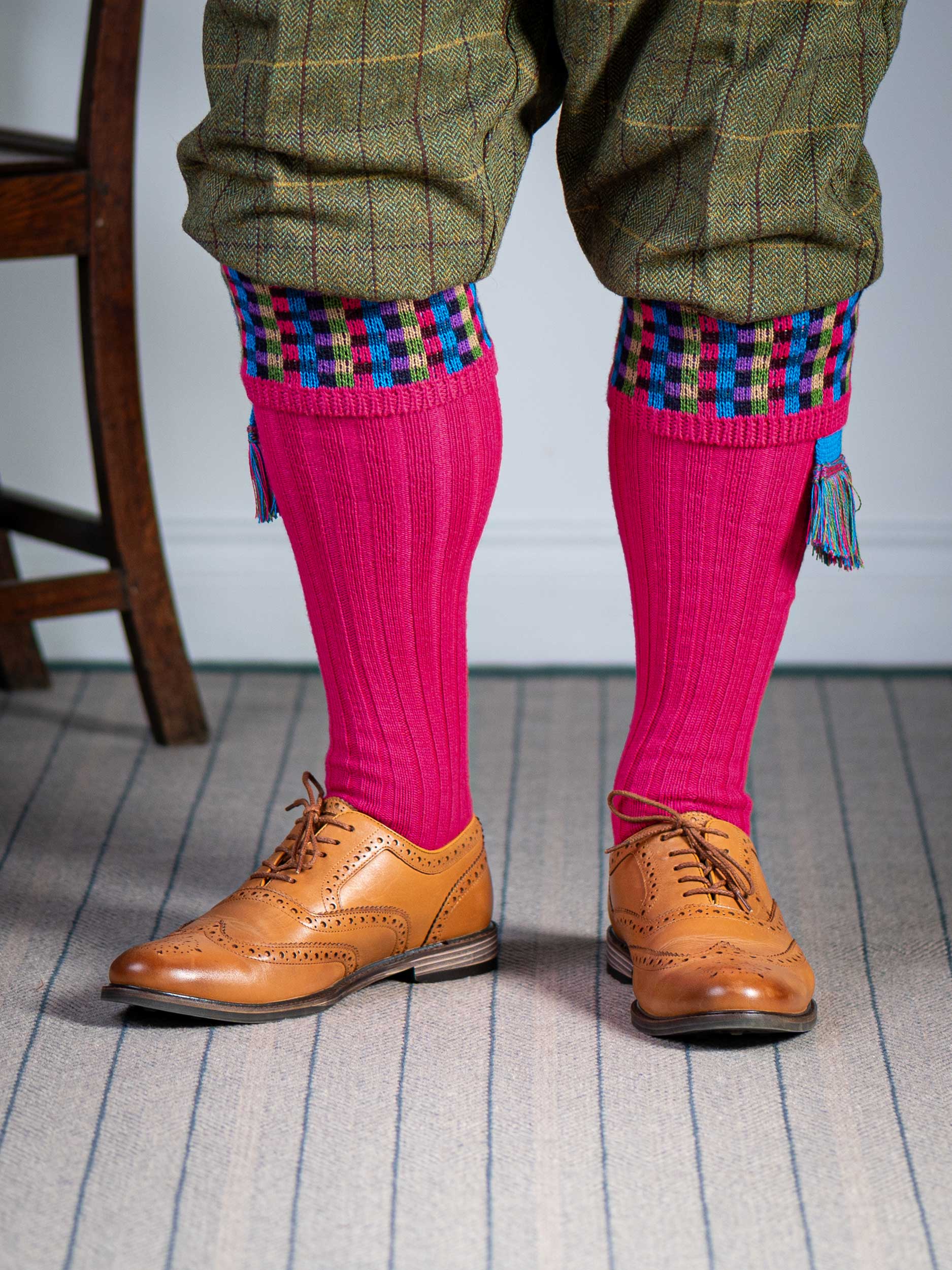 Long knitted shooting socks in bright pink with a ribbed leg, features 8 different colours in the pattern turnover top.