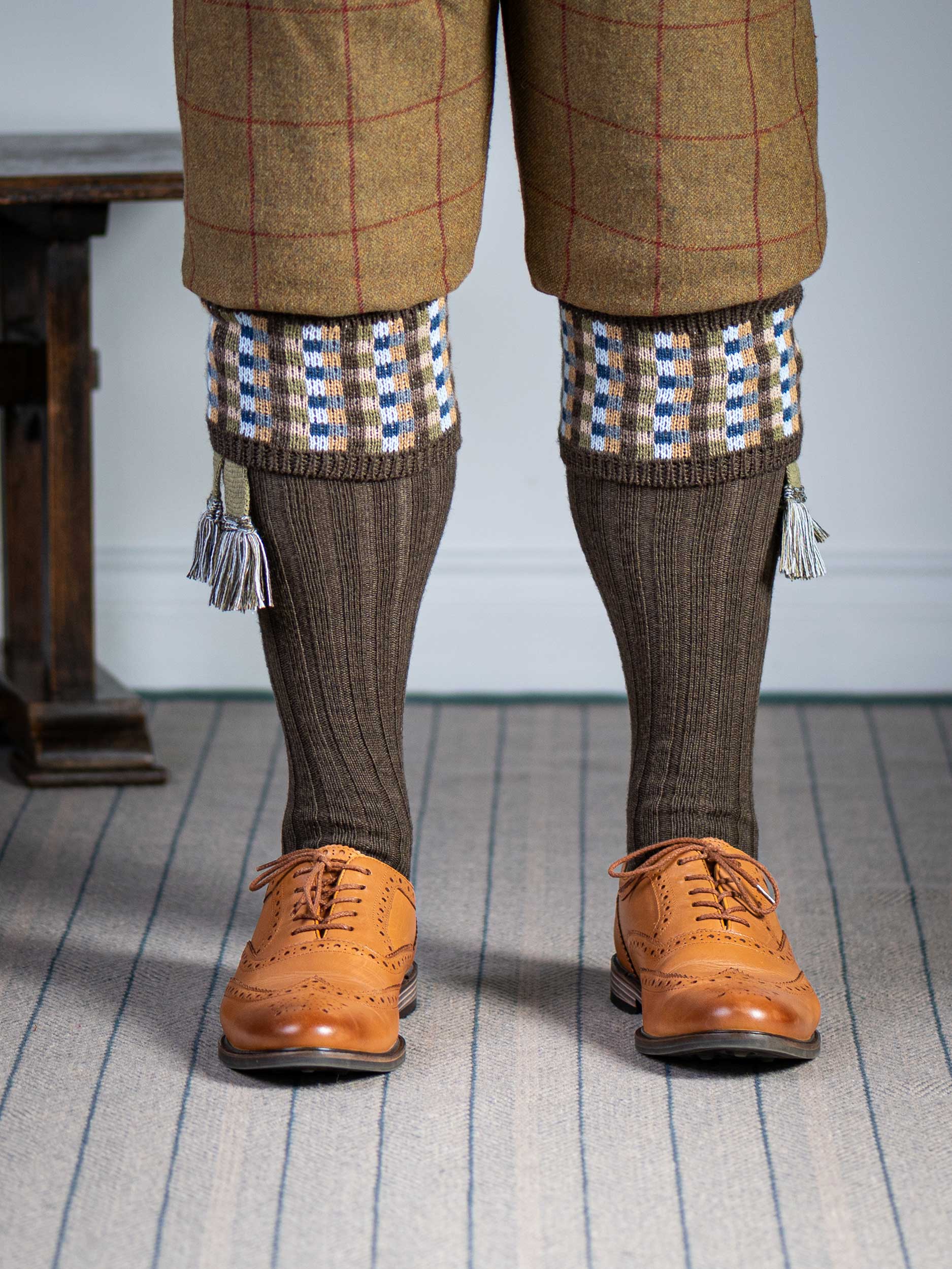 Long knitted shooting socks in earthy brown with a ribbed leg, features 8 different colours in the pattern turnover top.