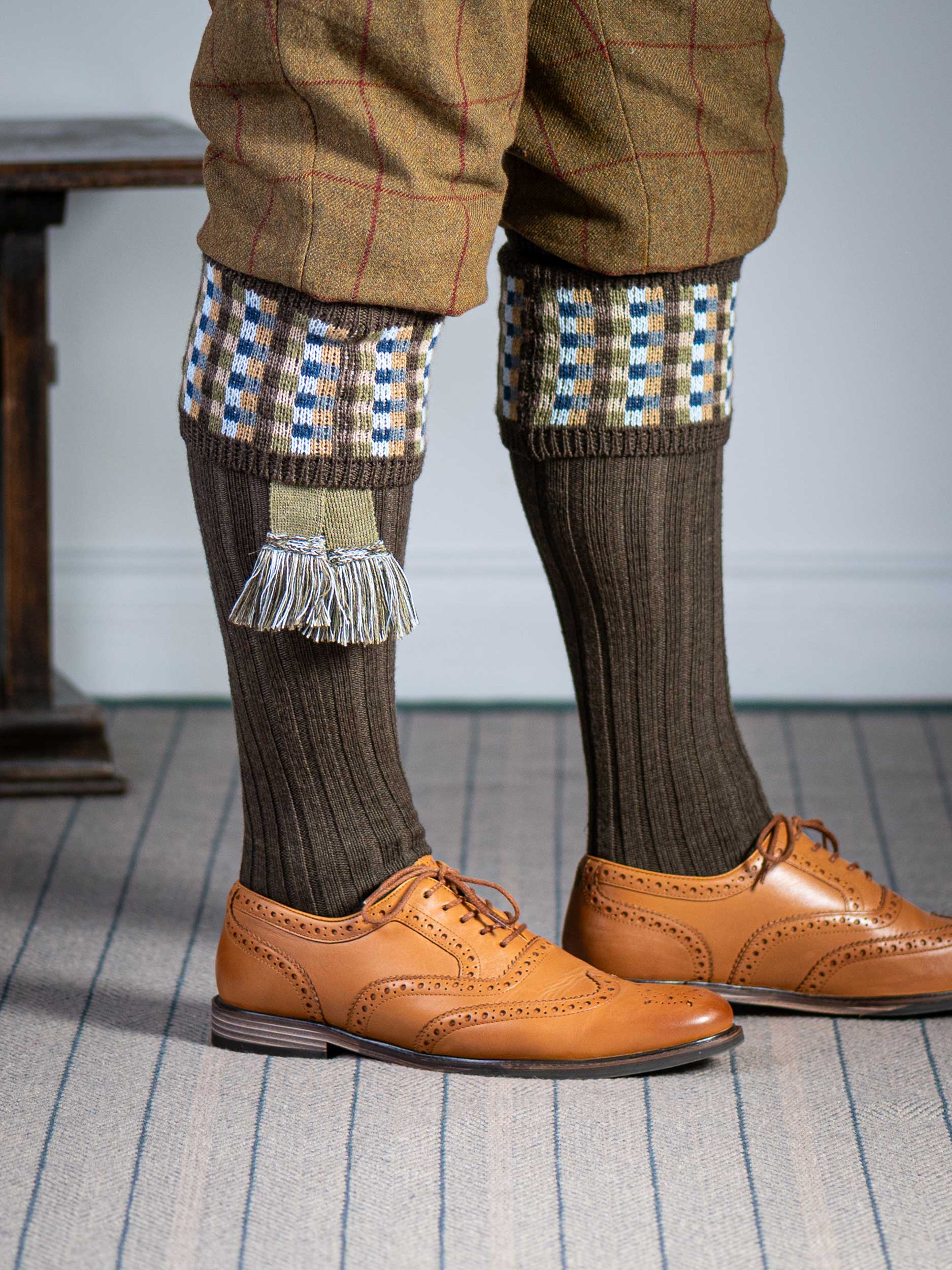 Long knitted shooting socks in earthy brown with a ribbed leg, features 8 different colours in the pattern turnover top.