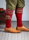 Traditional knitted shooting socks with a textured knitted top in brick red with green and beige pattern.