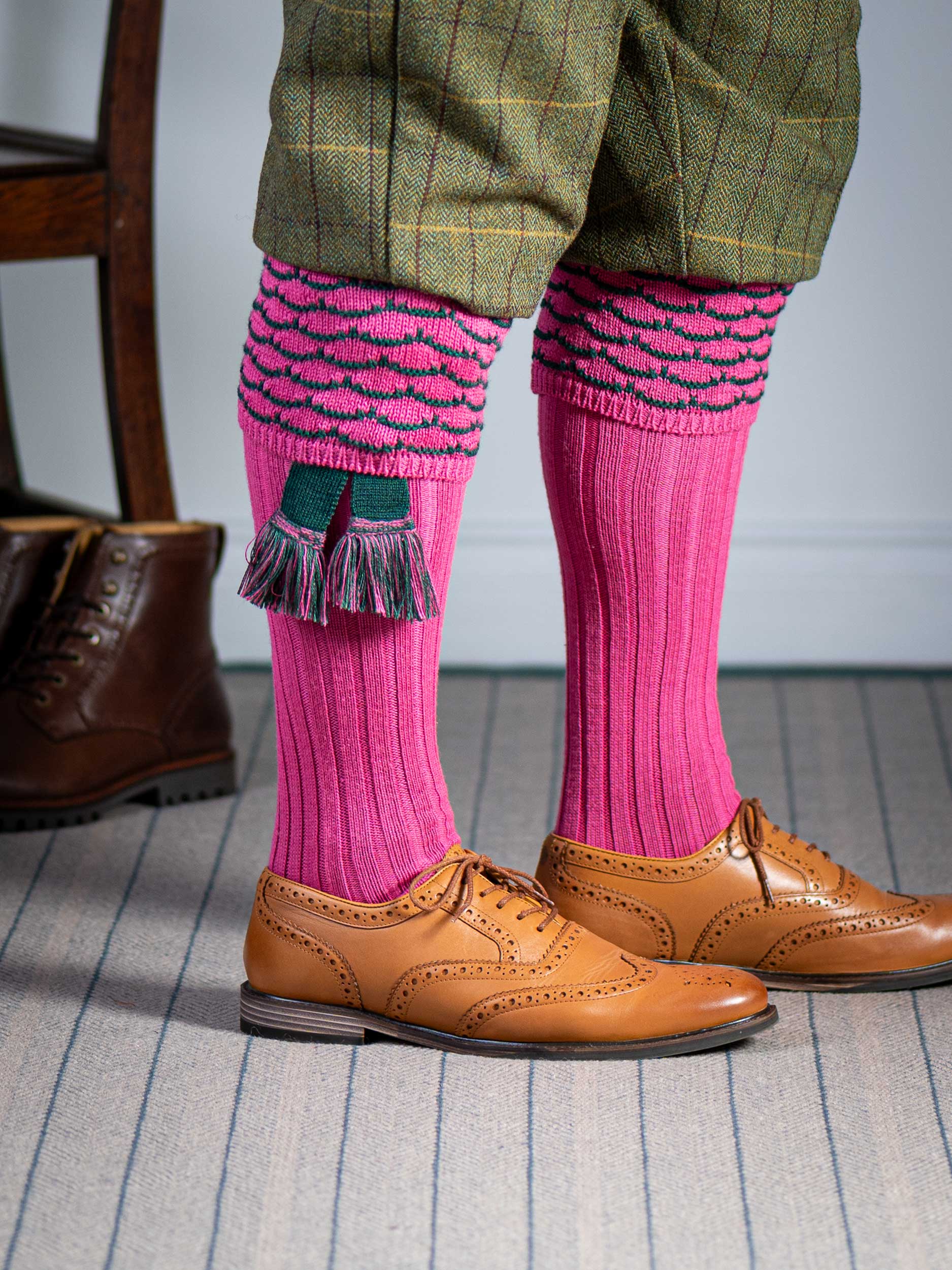 Traditional knitted shooting socks with ribbed leg in pink with a green scallop stitch detail in the turnover top