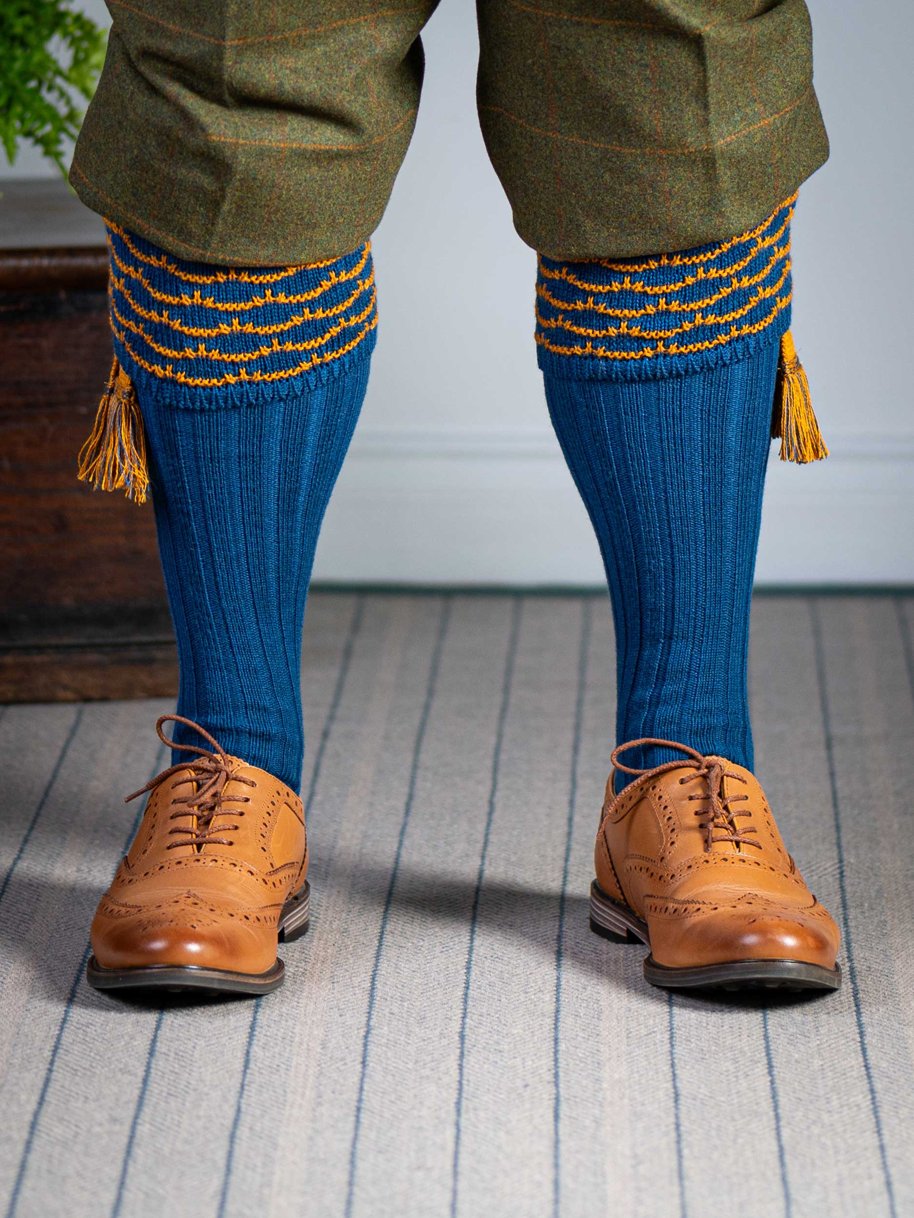 Traditional knitted shooting socks with ribbed leg in deep blue with a gold scallop stitch detail in the turnover top