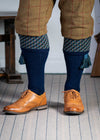 A contemporary technical shooting sock with supportive foot arch in navy blue with ancient blue and mulberry pattern in the turnover
