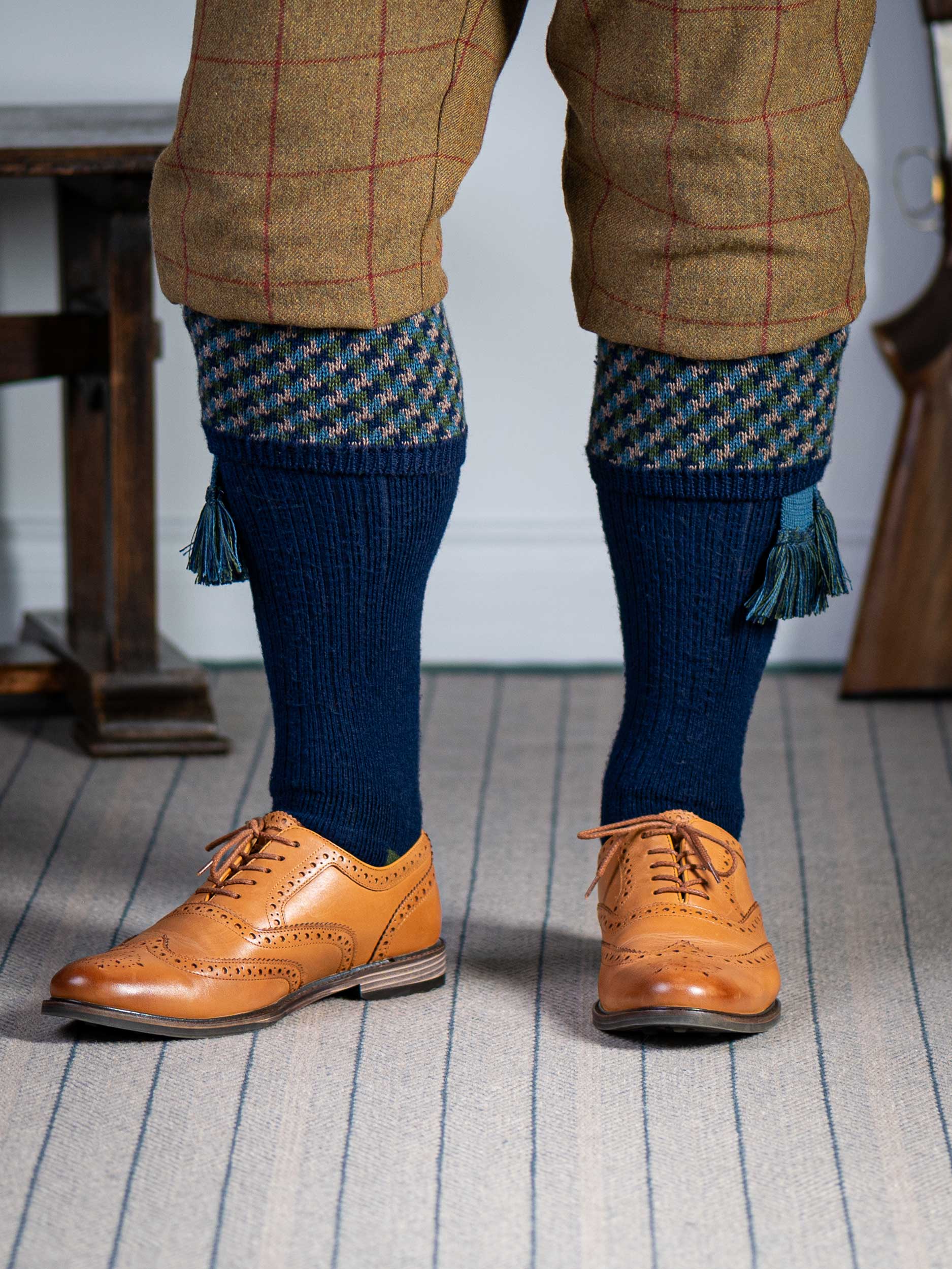 A contemporary technical shooting sock with supportive foot arch in navy blue with ancient blue and mulberry pattern in the turnover