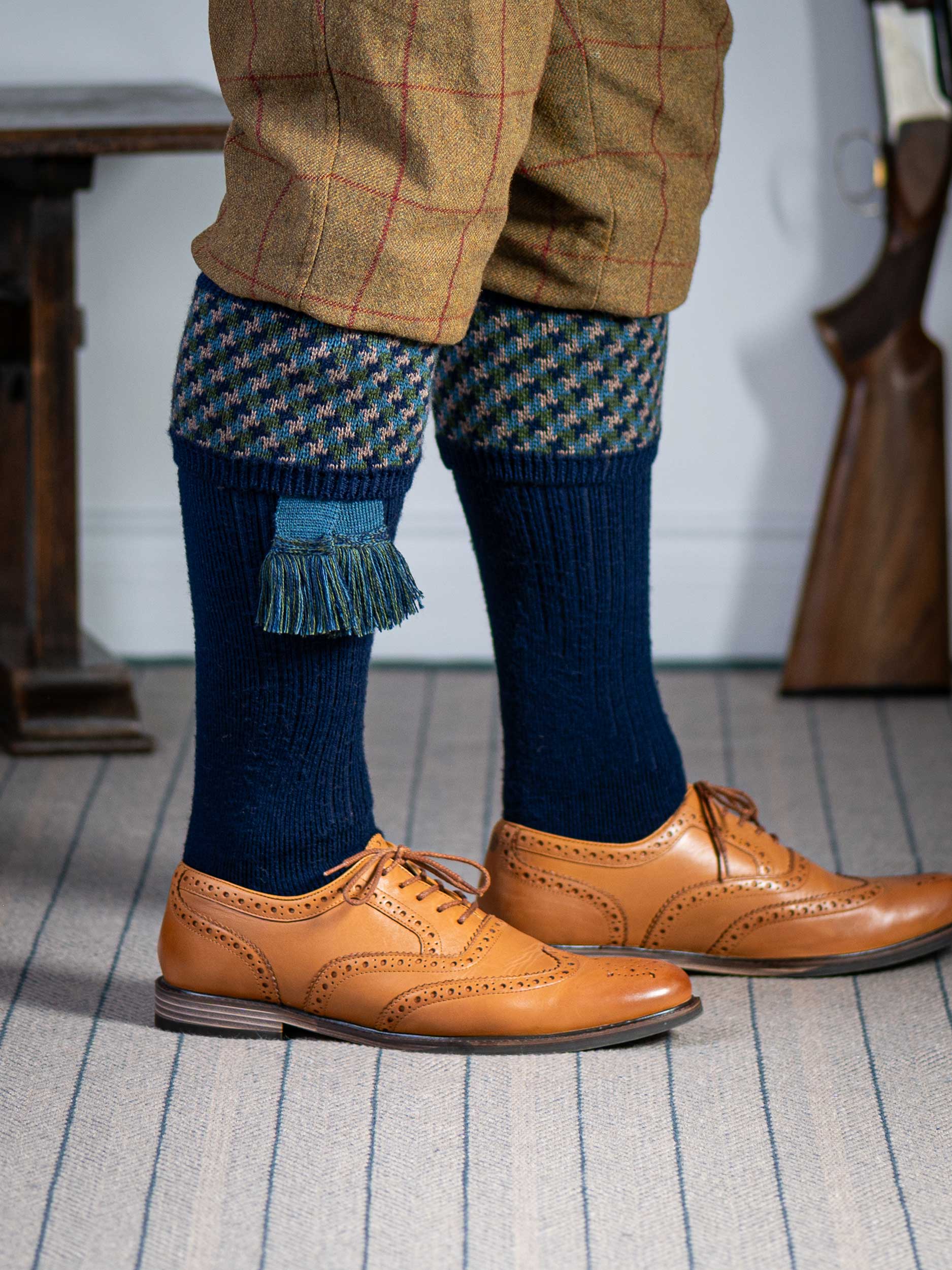 A contemporary technical shooting sock with supportive foot arch in navy blue with ancient blue and mulberry pattern in the turnover