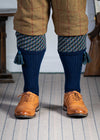 A contemporary technical shooting sock with supportive foot arch in navy blue with ancient blue and mulberry pattern in the turnover