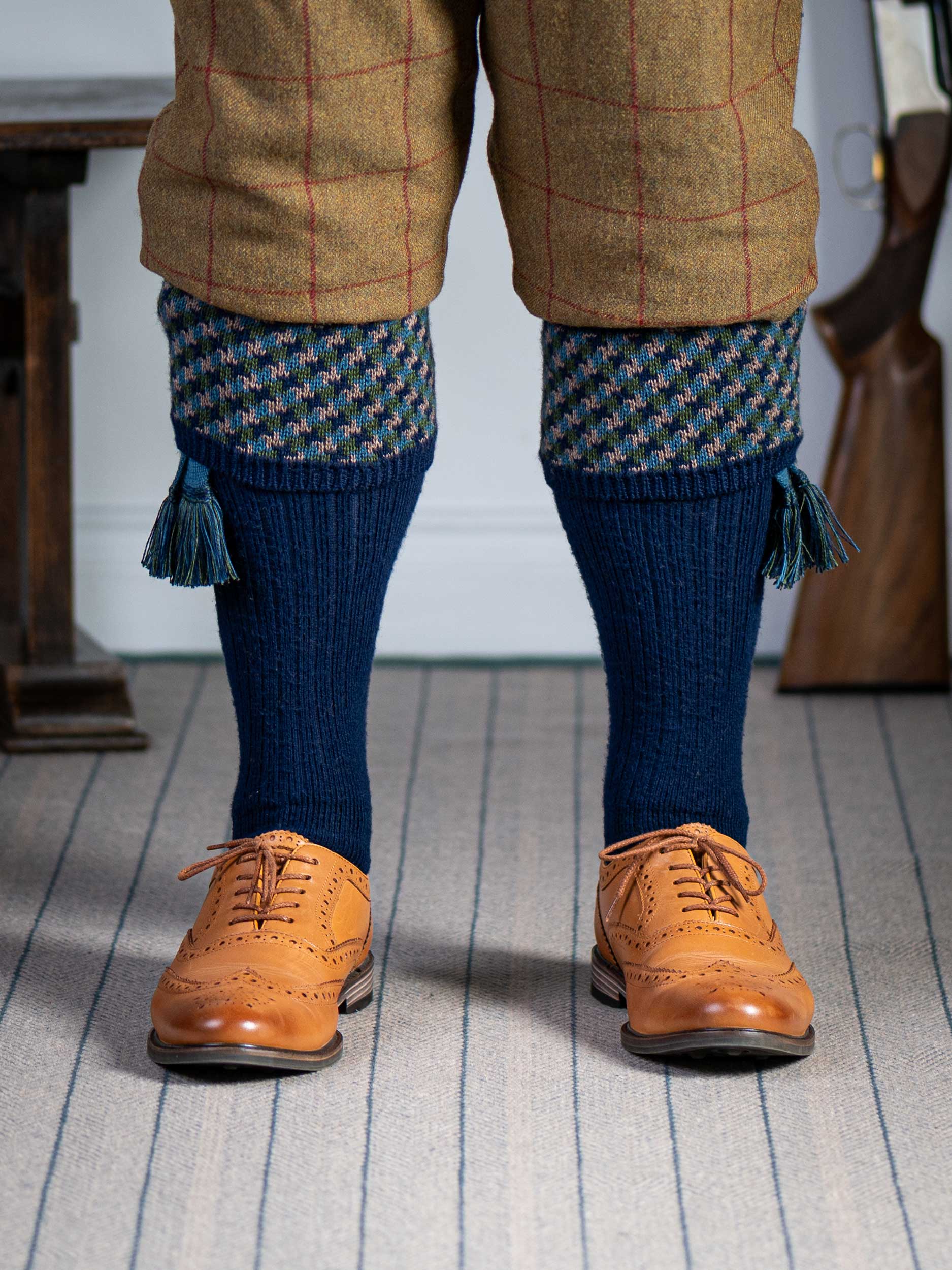 A contemporary technical shooting sock with supportive foot arch in navy blue with ancient blue and mulberry pattern in the turnover