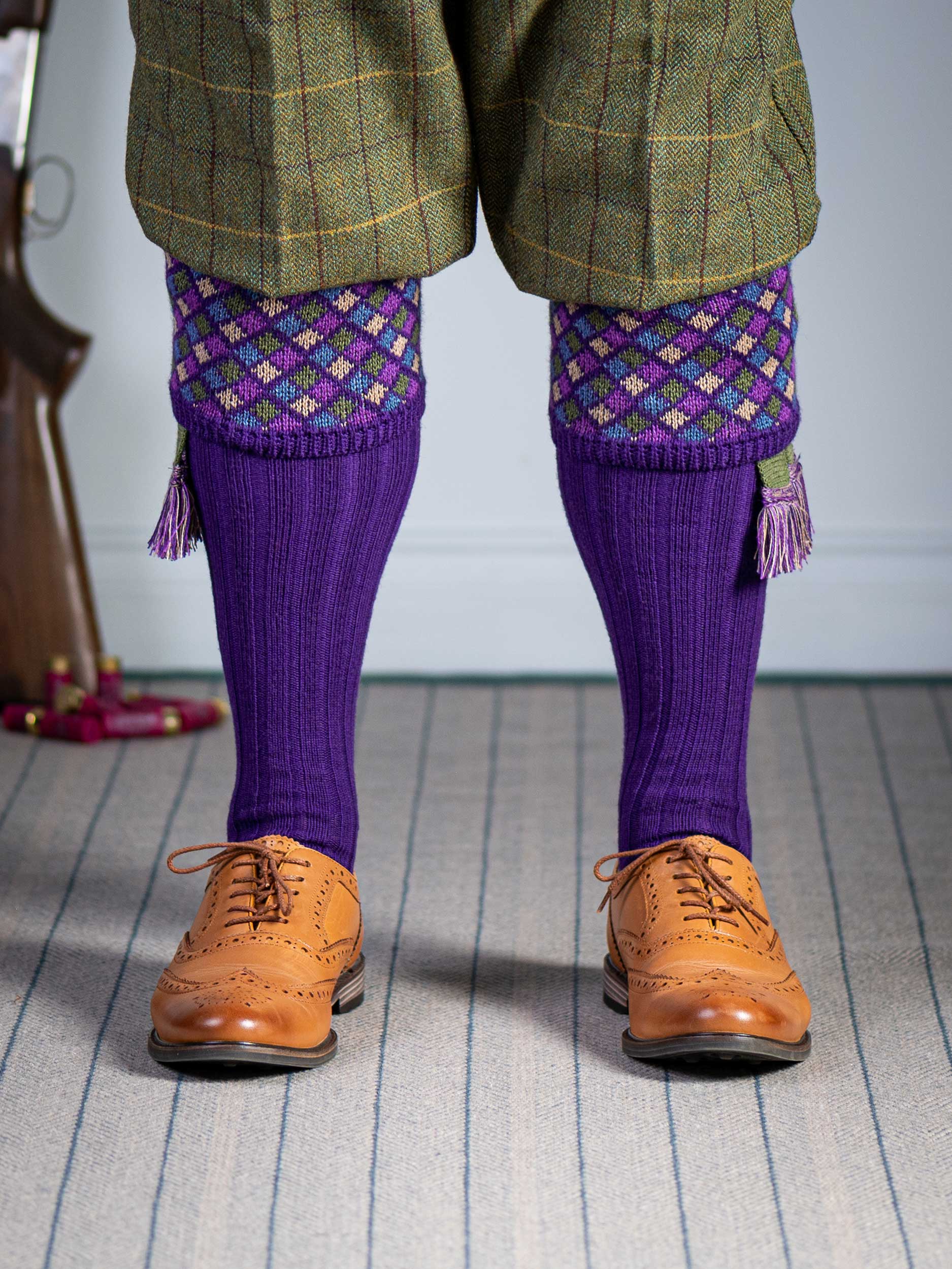 Long knitted shooting socks in bright purple with a ribbed leg, features 4 different colours in the argyle pattern turnover top.