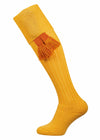 Yellow knee-high sock with orange tassels on a white background